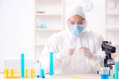 Laboratuvarda kimyasallar üzerinde çalışan genç bir kimyager.