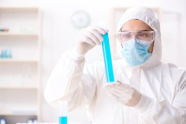 Laboratuvarda kimyasallar üzerinde çalışan genç bir kimyager.