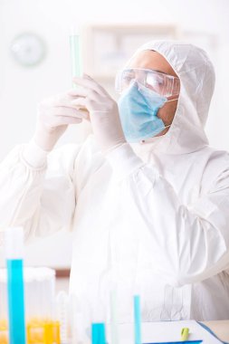 Laboratuvarda kimyasallar üzerinde çalışan genç bir kimyager.