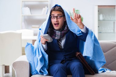 Çalışan işadamı grip olmuşken televizyon izliyor.