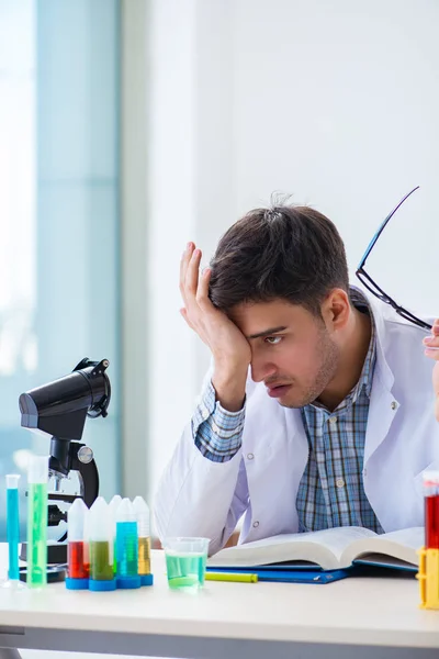 Joven estudiante de química trabajando en laboratorio sobre productos químicos —  Fotos de Stock