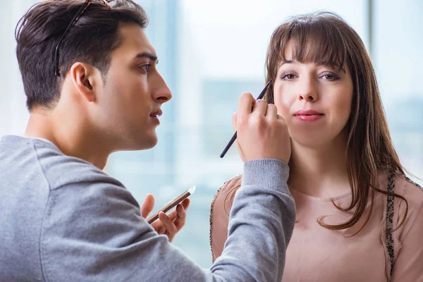 Homme faisant maquillage pour femme mignonne dans le salon de beauté — Photo