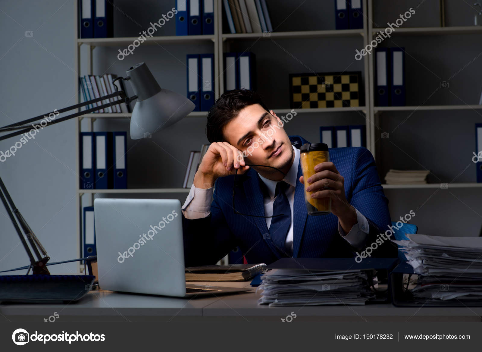 Employee Working Late And Drinking Strong Coffee To Stay Awake