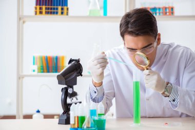 Laboratuvarda kimyasallar üzerinde çalışan genç bir kimyager.