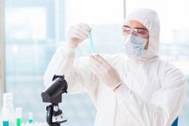 Laboratuvarda kimyasallar üzerinde çalışan genç bir kimyager.