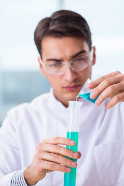 Laboratuvarda kimyasallar üzerinde çalışan genç bir kimyager.