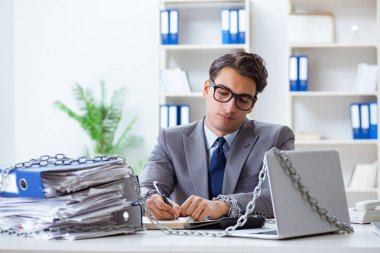 Ofis masasına zincirlenmiş meşgul bir çalışan.