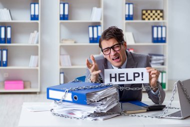 Ofis masasına zincirlenmiş meşgul bir çalışan.