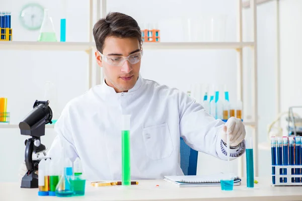 Jovem estudante de química que trabalha em laboratório em produtos químicos — Fotografia de Stock