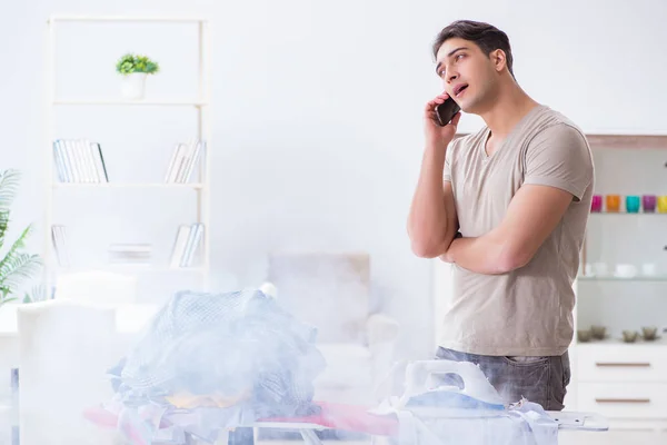 Esposo desatento quemando ropa mientras plancha —  Fotos de Stock