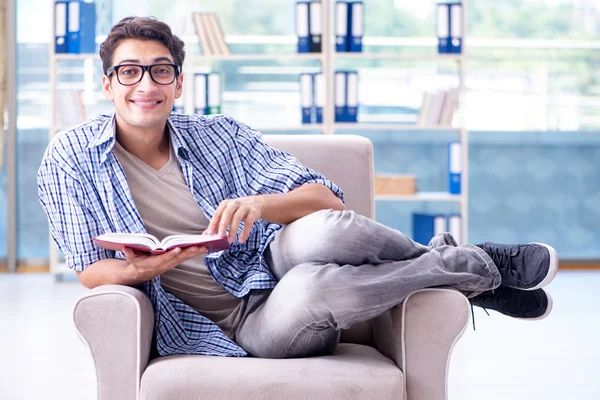 Estudiante leyendo libros y preparándose para los exámenes en la biblioteca —  Fotos de Stock