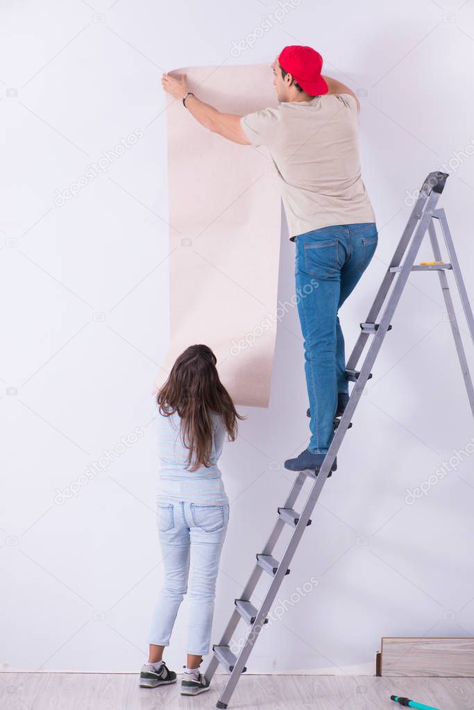 Young family doing renovation at home with new wallpaper