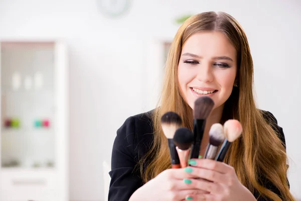 Mujer joven aplicando maquillaje preparándose para la fiesta —  Fotos de Stock