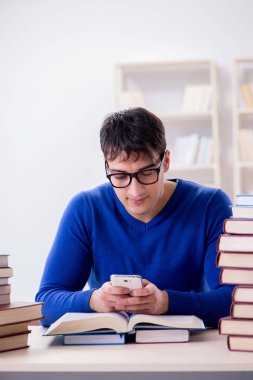 Erkek öğrenci üniversite kütüphanesinde sınava hazırlanıyor.