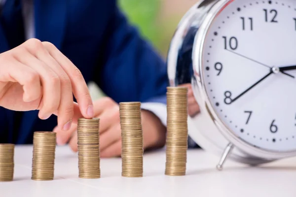 Empresario con pilas de monedas en la oficina — Foto de Stock