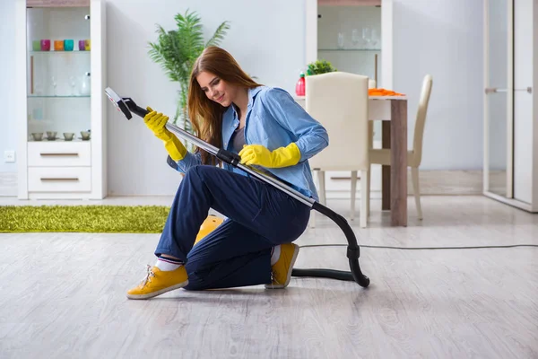 Молодая женщина убирает пол дома, выполняя работу по дому — стоковое фото