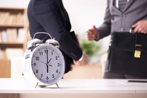 Businessman employee in urgency and deadline concept with alarm 