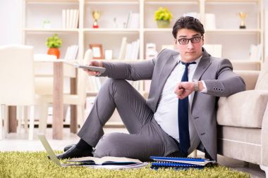 İş adamı evde yerde çalışıyor.