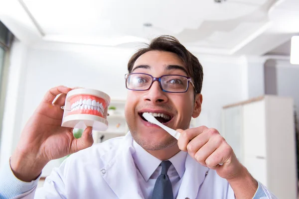 Funny dentist with toothbrush in medical concept