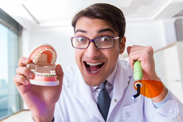 Zabawny dentysta z utwardzaniem światła w koncepcji medycznej — Zdjęcie stockowe