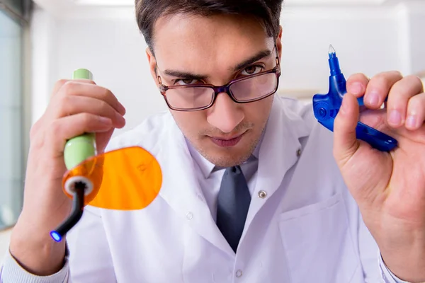 Funny dentist with curing light in medical concept