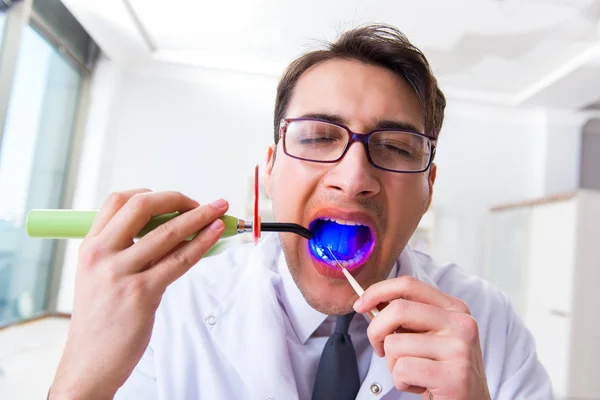 Tıp konseptinde tedavi edici ışığı olan komik dişçi. — Stok fotoğraf