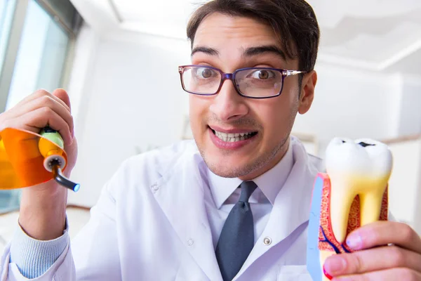 Funny dentist with curing light in medical concept