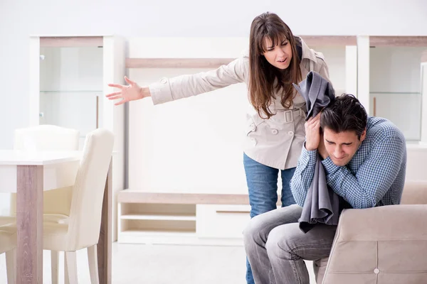 Young couple disappointed with price in furniture store