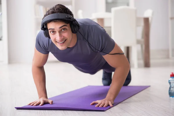 Adam evde spor yapıyor ve müzik dinliyor. — Stok fotoğraf