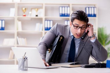 İşadamı ofis telefonundan konuşuyor.