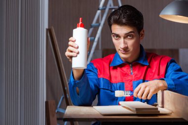 Genç adam ahşap parçaları DIY konseptinde yapıştırıyor.