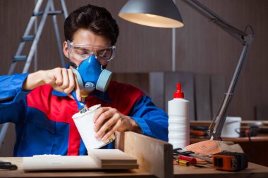 Genç adam ahşap parçaları DIY konseptinde yapıştırıyor.