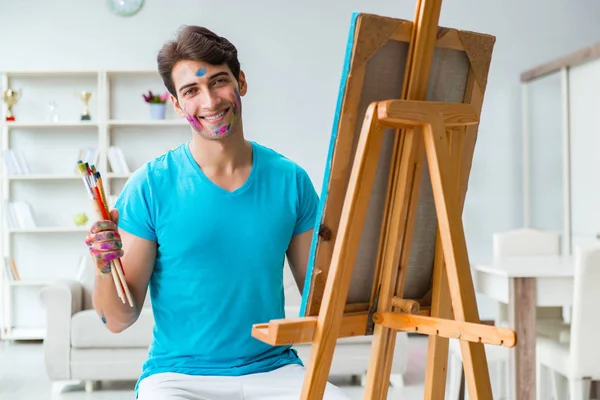 Jonge grappige kunstenaar werkt aan nieuw schilderij in zijn atelier — Stockfoto