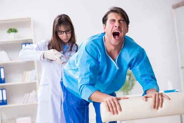 Funny man getting ready for buttocks syringe shot — Stock Photo, Image