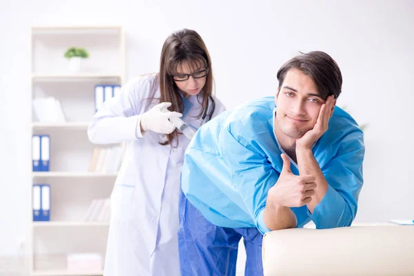 Funny man getting ready for buttocks syringe shot — Stock Photo, Image