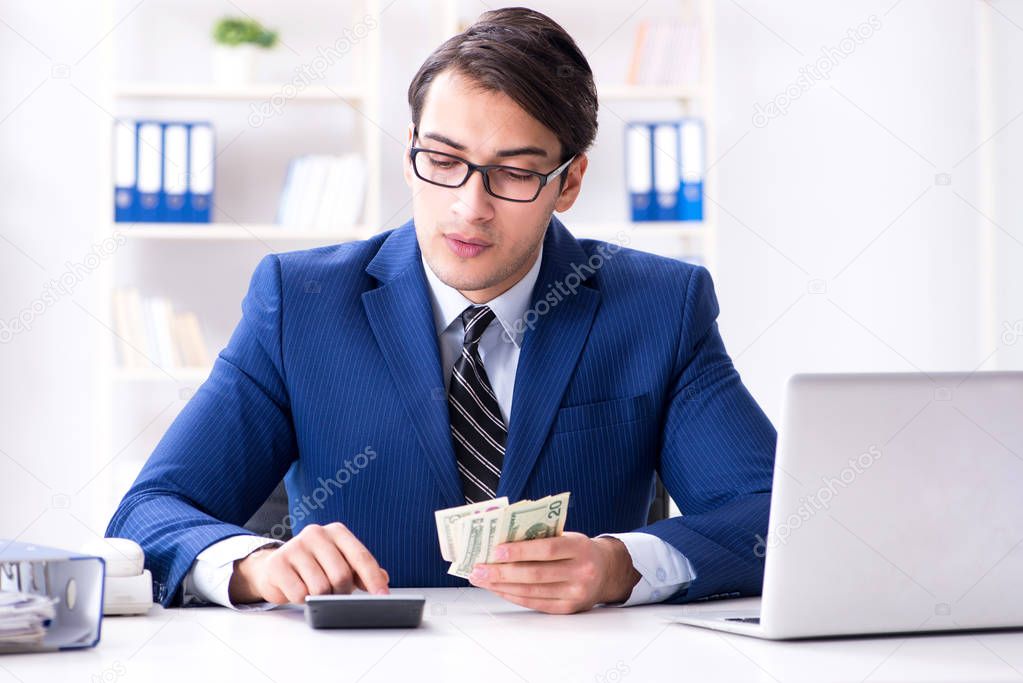 Accountant calculating dollars with calculator in office