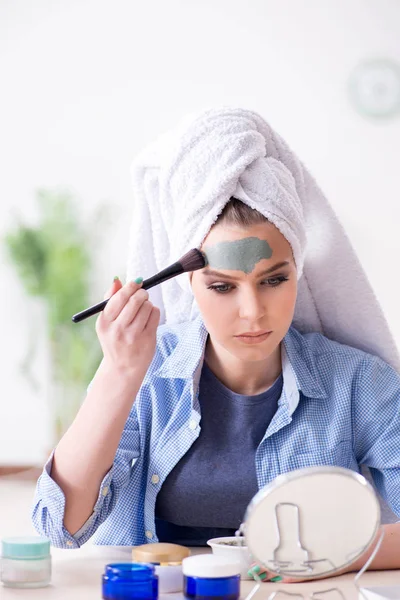 Mujer aplicando mascarilla de barro con cepillo en casa — Foto de Stock