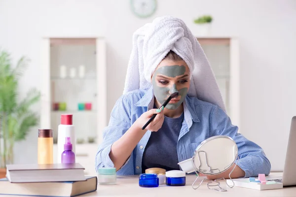 Kobieta nakładająca glinianą maskę ze szczotką w domu — Zdjęcie stockowe