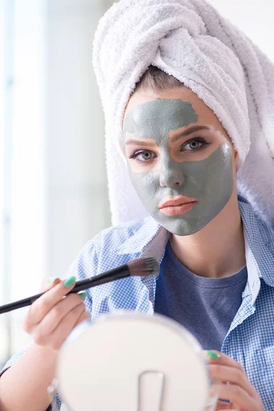 Mujer aplicando mascarilla de barro con cepillo en casa — Foto de Stock