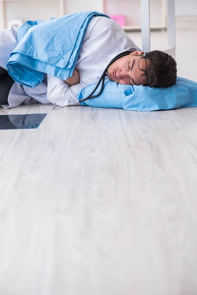Γιατρός κοιμάται στο πάτωμα μετά από μεγάλη νυχτερινή βάρδια — Φωτογραφία Αρχείου