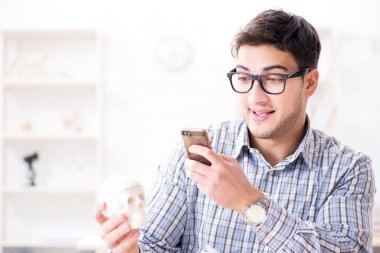 Tıp öğrencisi iskeleti inceliyor.