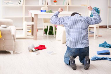 Hırsızlar tarafından soyulduktan sonra evini bulan bir adam.