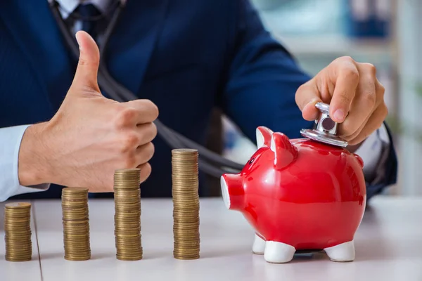 Geschäftsmann mit Stapeln von Münzen im Büro — Stockfoto