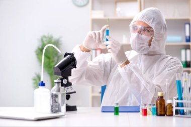 Laboratuvarda kimyasallar üzerinde çalışan genç bir kimyager.
