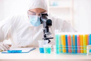 Laboratuvarda kimyasallar üzerinde çalışan genç bir kimyager.