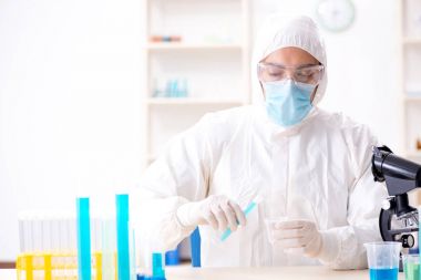 Laboratuvarda kimyasallar üzerinde çalışan genç bir kimyager.