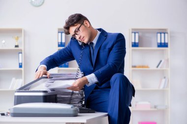 Businessman making copies in copying machine clipart