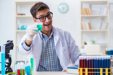 Laboratuvarda kimyasallar üzerinde çalışan genç bir kimyager.
