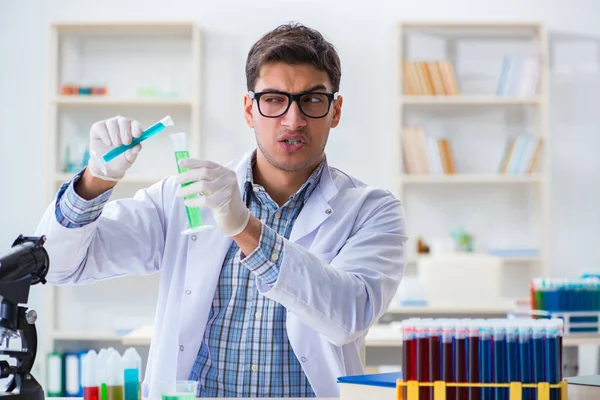 Giovane studente di chimica che lavora in laboratorio sui prodotti chimici — Foto Stock