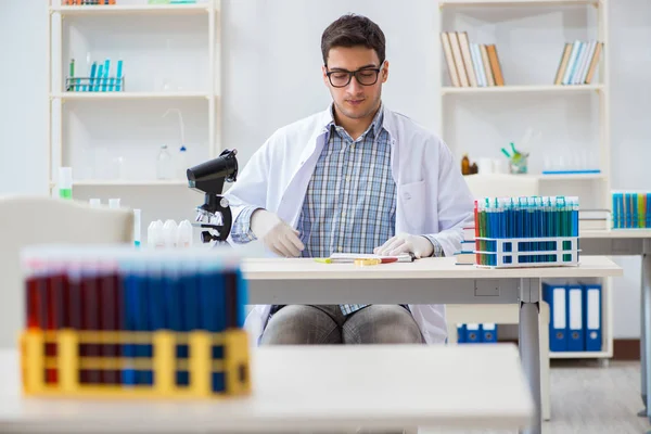 Jovem estudante de química que trabalha em laboratório em produtos químicos — Fotografia de Stock